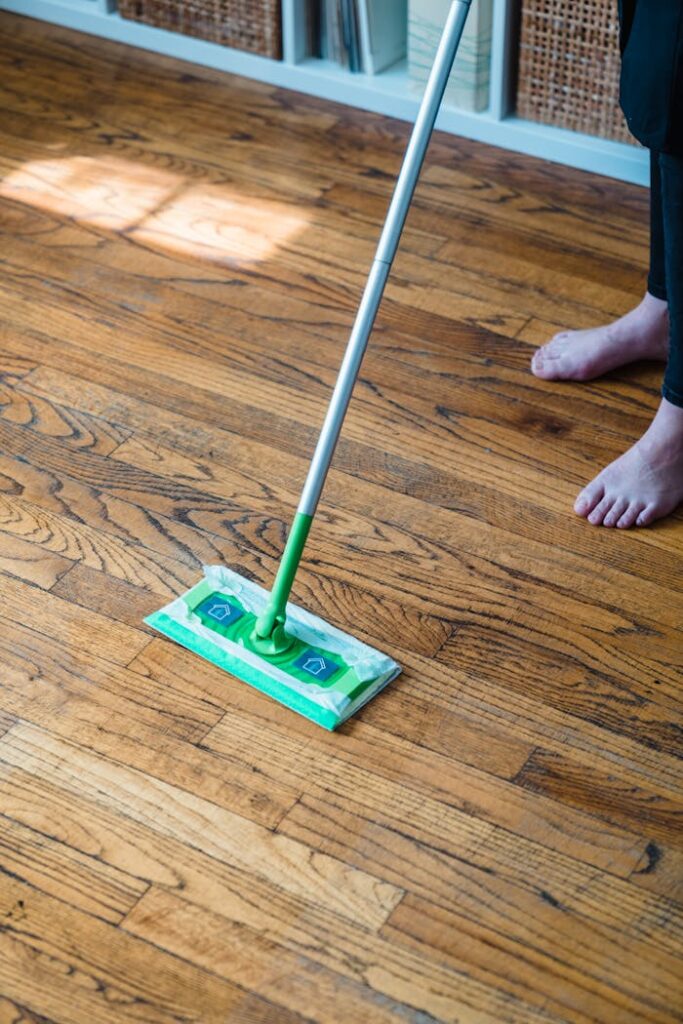 A Person Sweeping a Wooden Floor